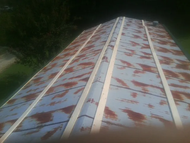Rusted metal roof panels with new wood purlins before replacement — Storm Damage Roof Repair in Triangle by Roofing Brothers