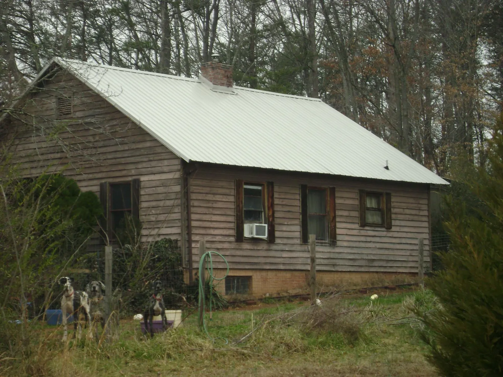White metal roof on an old wood sided farmhouse, from a Metal Roof Installation job in Triangle